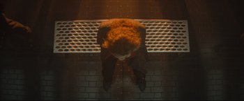 Movie still from “Bullet Train” (2022), directed by David Leitch – A woman sitting on a ledge looking up at the ceiling; Wide shot, Overhead angle