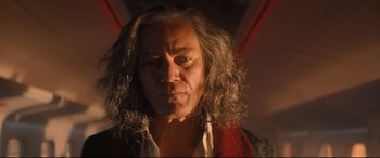 Movie still from “Bullet Train” (2022), directed by David Leitch – An older man with long hair and a red shirt; Close Up shot, Low angle
