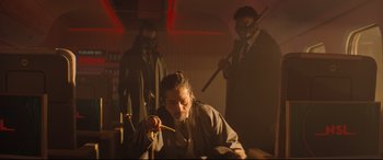 Movie still from “Bullet Train” (2022), directed by David Leitch – A group of people in a room with masks on; Medium shot, Low angle