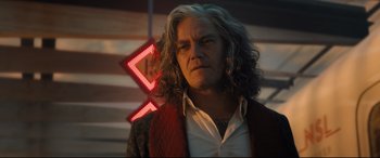 Movie still from “Bullet Train” (2022), directed by David Leitch – A man with long white hair standing in front of a neon sign; Close Up shot, Low angle
