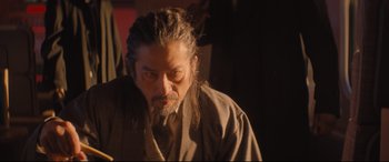 Movie still from “Bullet Train” (2022), directed by David Leitch – A man with dreadlocks is looking at the camera; Close Up shot, Low angle