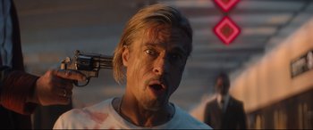 Movie still from “Bullet Train” (2022), directed by David Leitch – A person holding a gun; Close Up shot, Low angle