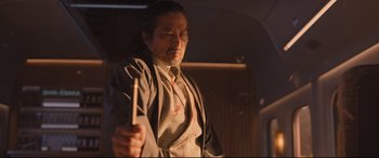 Movie still from “Bullet Train” (2022), directed by David Leitch – A man holding a wooden stick with blood on it; Medium shot, Low angle
