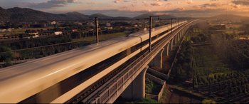 Movie still from “Bullet Train” (2022), directed by David Leitch – A train traveling over a bridge on a cloudy day; Extreme Wide shot, Low angle