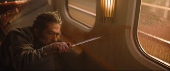 Movie still from “Bullet Train” (2022), directed by David Leitch – A man holding a sword on top of a train car; Medium shot, Low angle
