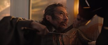 Movie still from “Bullet Train” (2022), directed by David Leitch – A person holding a knife in his hand; Close Up shot, Low angle