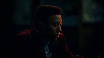Movie still from “The Midnight Club” (2022), created by Mike Flanagan – A man sitting in a dark room looking at something; Close Up shot, Low angle