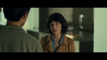 Movie still from “The Midnight Club” (2022), created by Mike Flanagan – A woman wearing a brown jacket talking to a man in a suit; Medium shot, Over the shoulder angle
