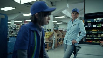 Movie still from “The Midnight Club” (2022), created by Mike Flanagan – A woman standing next to a boy in a store; Medium shot, Over the shoulder angle