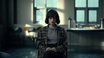 Movie still from “The Midnight Club” (2022), created by Mike Flanagan – A person sitting in a chair in a room; Medium shot, Over the shoulder angle