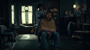 Movie still from “The Midnight Club” (2022), created by Mike Flanagan – A man getting his hair cut by a woman; Medium shot, Low angle