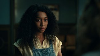 Movie still from “The Midnight Club” (2022), created by Mike Flanagan – A young woman with long black curly hair wearing an overalls; Close Up shot, Over the shoulder angle