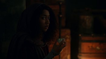 Movie still from “The Midnight Club” (2022), created by Mike Flanagan – A person holding a cup in a dark room; Close Up shot, Over the shoulder angle