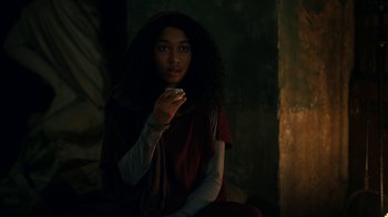 Movie still from “The Midnight Club” (2022), created by Mike Flanagan – A woman sitting in a dark room holding a cell phone; Close Up shot, Over the shoulder angle