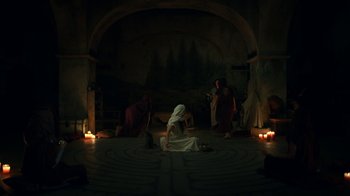 Movie still from “The Midnight Club” (2022), created by Mike Flanagan – A woman sitting on the ground in a circle of candles; Wide shot, High angle