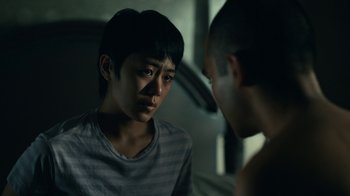 Movie still from “The Midnight Club” (2022), created by Mike Flanagan – Two young men are looking at each other in a dark room; Close Up shot, Over the shoulder angle