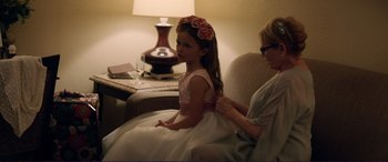 Movie still from “The Mule” (2018), directed by Clint Eastwood – A woman helping a little girl put on a flower crown; Medium shot, Over the shoulder angle