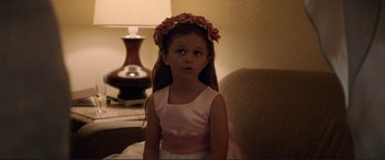 Movie still from “The Mule” (2018), directed by Clint Eastwood – A little girl wearing a pink dress and a flower crown; Close Up shot, Over the shoulder angle