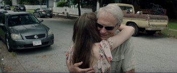 Movie still from “The Mule” (2018), directed by Clint Eastwood – An older man hugging a young woman on the side of the road; Close Up shot, Over the shoulder angle