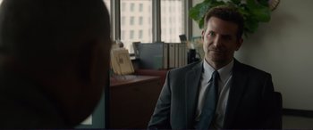 Movie still from “The Mule” (2018), directed by Clint Eastwood – A man in a suit and tie in a room; Medium shot, Over the shoulder angle