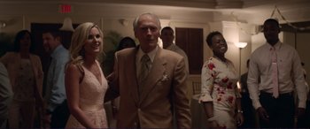 Movie still from “The Mule” (2018), directed by Clint Eastwood – A group of people standing in a living room; Medium shot, Over the shoulder angle