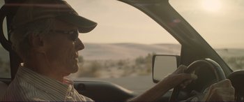 Movie still from “The Mule” (2018), directed by Clint Eastwood – A man driving a car in the desert; Close Up shot, Over the shoulder angle