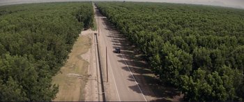Movie still from “The Mule” (2018), directed by Clint Eastwood – An aerial view of a road with a truck driving down it; Extreme Wide shot, High angle
