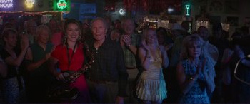 Movie still from “The Mule” (2018), directed by Clint Eastwood – A group of people standing in front of a bar; Wide shot, Over the shoulder angle