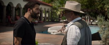 Movie still from “The Mule” (2018), directed by Clint Eastwood – A man in a hat talking to another man in a suit; Medium shot, Over the shoulder angle