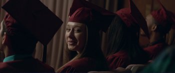 Movie still from “The Mule” (2018), directed by Clint Eastwood – A girl in a cap and gown smiling for the camera; Close Up shot, Over the shoulder angle