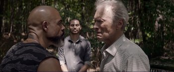 Movie still from “The Mule” (2018), directed by Clint Eastwood – Two men and a man in the background; Close Up shot, Over the shoulder angle
