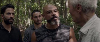 Movie still from “The Mule” (2018), directed by Clint Eastwood – A man with a long beard and a mustache is standing next to another man with a long beard; Medium shot, Over the shoulder angle