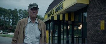 Movie still from “The Mule” (2018), directed by Clint Eastwood – An older man standing in front of a waffle house; Medium shot, Low angle