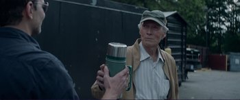 Movie still from “The Mule” (2018), directed by Clint Eastwood – An older man holding a thermos in his hand; Medium shot, Over the shoulder angle