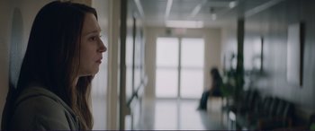 Movie still from “The Mule” (2018), directed by Clint Eastwood – A woman looking out the window of a building; Close Up shot, Over the shoulder angle