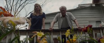 Movie still from “The Mule” (2018), directed by Clint Eastwood – A man and a woman standing next to a railing; Medium shot, Low angle