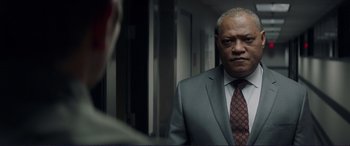 Movie still from “The Mule” (2018), directed by Clint Eastwood – A man in a suit and tie looking at himself in the mirror; Close Up shot, Over the shoulder angle