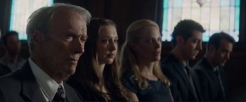 Movie still from “The Mule” (2018), directed by Clint Eastwood – A group of people sitting next to each other in front of a window; Close Up shot, Low angle