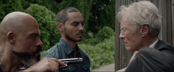 Movie still from “The Mule” (2018), directed by Clint Eastwood – A man holding a gun talking to another man; Close Up shot, Over the shoulder angle