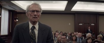 Movie still from “The Mule” (2018), directed by Clint Eastwood – An old man in a suit and tie in front of an audience; Close Up shot, Low angle
