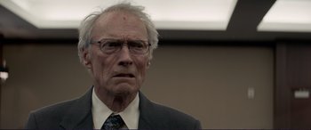 Movie still from “The Mule” (2018), directed by Clint Eastwood – An older man wearing a suit and tie; Close Up shot, Low angle