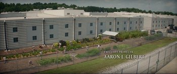 Movie still from “The Mule” (2018), directed by Clint Eastwood – An image of an outside area with a fence and a garden; Extreme Wide shot, High angle