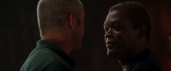 Movie still from “The Negotiator” (1998), directed by F. Gary Gray – Two men talking to each other in a dark room; Close Up shot, Over the shoulder angle