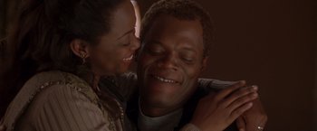 Movie still from “The Negotiator” (1998), directed by F. Gary Gray – A man and a woman smiling for the camera; Close Up shot, Low angle