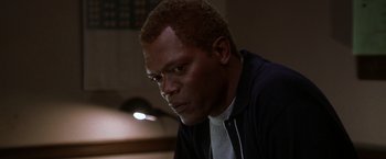 Movie still from “The Negotiator” (1998), directed by F. Gary Gray – A person sitting down with his head down; Close Up shot, High angle