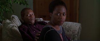 Movie still from “The Negotiator” (1998), directed by F. Gary Gray – A man and a woman sitting on a couch together; Close Up shot, Over the shoulder angle