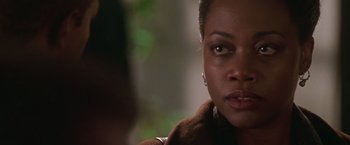 Movie still from “The Negotiator” (1998), directed by F. Gary Gray – A woman's face in a wooded area; Close Up shot, Over the shoulder angle