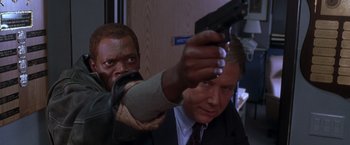 Movie still from “The Negotiator” (1998), directed by F. Gary Gray – A man holding a gun up to a man's face; Close Up shot, Low angle
