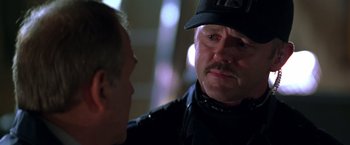 Movie still from “The Negotiator” (1998), directed by F. Gary Gray – A police officer talking to a man in a uniform; Close Up shot, Over the shoulder angle