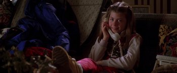 Movie still from “The Negotiator” (1998), directed by F. Gary Gray – A young girl sitting on the ground talking on a phone; Medium shot, High angle